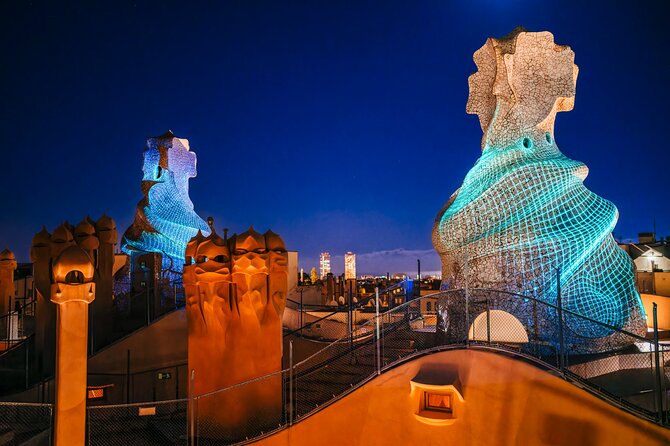 Warrior-shaped chimneys on the rooftop terrace of La Pedrera with the Barcelona skyline behind