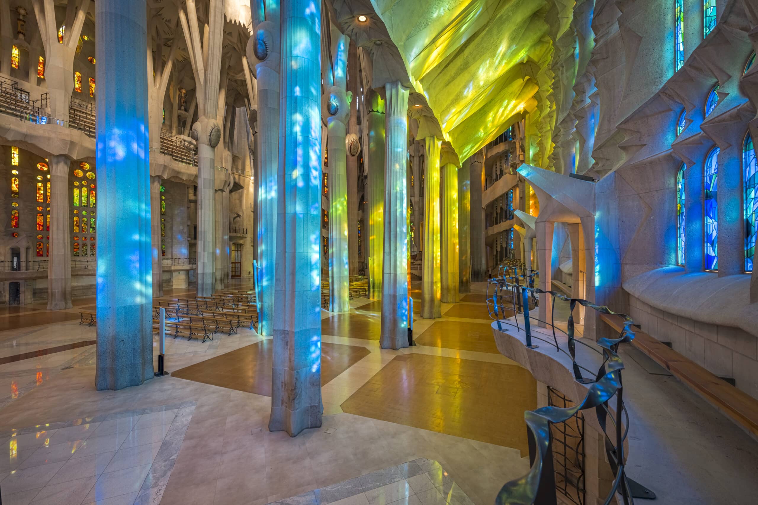 Sonnenlicht fällt durch die orangefarbenen und roten Glasfenster im Inneren der Sagrada Família